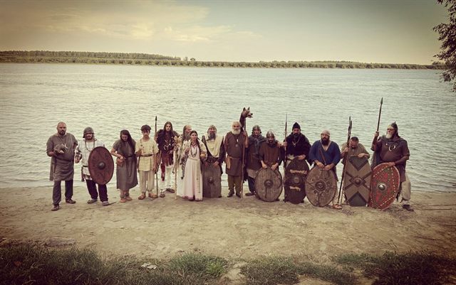Membrii Omnis Barbaria aliniați pe malul unui râu